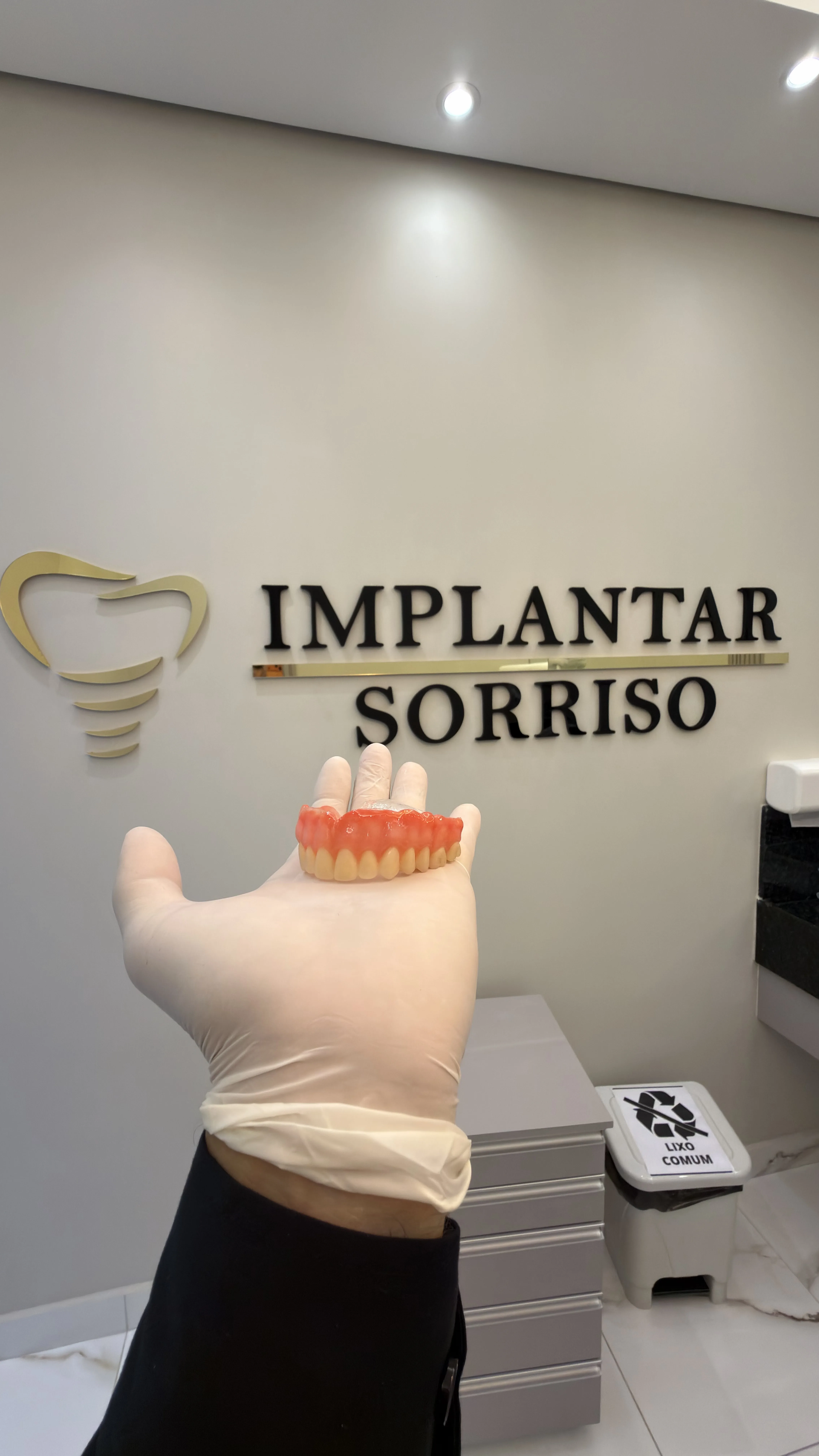 Prótese dentária com logo Implantar Sorriso